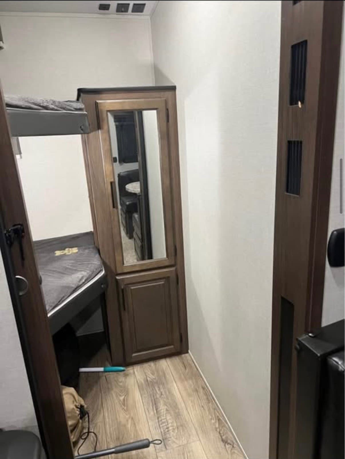 The two twin XL bunk beds in The Crusader, made up with mattresses and closed off behind their own door, with a tall mirrored wardrobe alongside